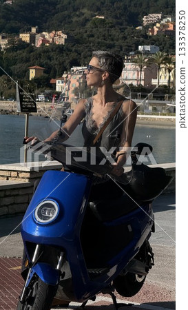 Woman Riding Blue Scooter Along Scenic Coastline Woman Riding Blue Scooter Along Scenic Coastline 133378250