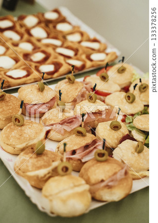 Assorted Sandwiches with Olives and Savory Pastries Assorted Sandwiches with Olives and Savory Pastries 133378256