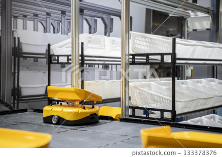 Automatic warehouse robot car carries cardboard box assembly in factory. 133378376