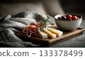 an elegant charcuterie board with slices of prosciutto or jamon, cheese, and olives on it. 133378499