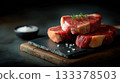 Premium boneless ribeye steaks with heavy marbling, thick cut, displayed in neat stack on black slate board 133378503