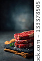 Premium boneless ribeye steaks with heavy marbling, thick cut, displayed in neat stack on black slate board 133378505