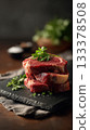 Premium boneless ribeye steaks with heavy marbling, thick cut, displayed in neat stack on black slate board 133378508