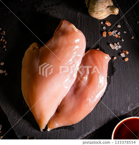 Raw meat chicken breast with thyme herbs and whole pepper on black backdrop 133378554
