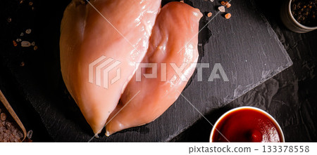Raw meat chicken breast with thyme herbs and whole pepper on black backdrop 133378558