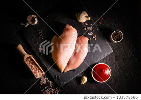 Raw meat chicken breast with thyme herbs and whole pepper on black backdrop 133378560