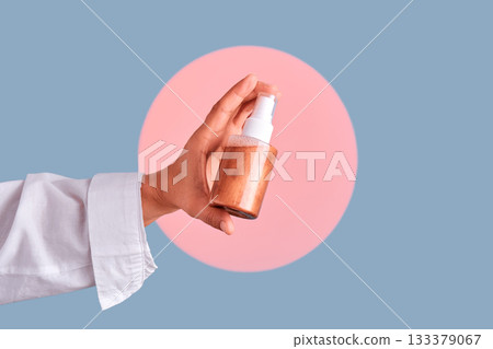 Hand holding spray bottle with bronzer cosmetics 133379067