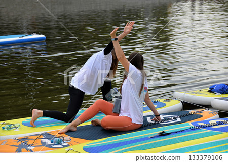 SUP yoga, two girls 133379106