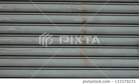Surface of an old and worn metal shutter door Surface of an old and worn metal shutter door 133379235