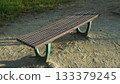 Wooden bench on sandy ground in outdoor park 133379245