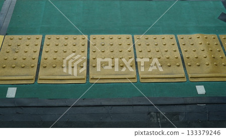 Yellow Braille blocks on the floor of a Japanese subway station 133379246