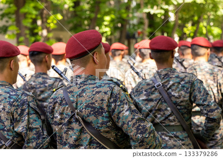 Young Asian men in military uniforms marching in formation outdoors Young Asian men in military uniforms marching in formation outdoors 133379286