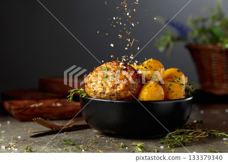Roasted potatoes with cutlet sprinkled with spices. Roasted potatoes with cutlet sprinkled with spices. 133379340