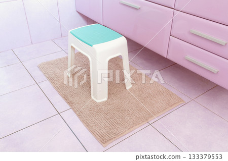 Plastic chair on rectangle beige carpet in bathroom Plastic chair on rectangle beige carpet in bathroom 133379553