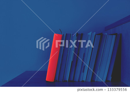 Books illuminated by night light and one book with red cover 133379556