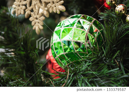 Christmas tree with green ball and shiny lights garland. Xmas greeting card. Close up. Winter. Outdoors. Christmas tree with green ball and shiny lights garland. Xmas greeting card. Close up. Winter. Outdoors. 133379587