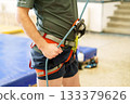 Man adjusting climbing harness before indoor training 133379626
