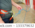 Man tying safety knot for indoor climbing 133379632