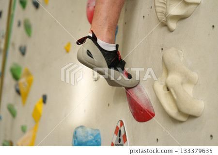 Feet on climbing wall in indoor gym 133379635