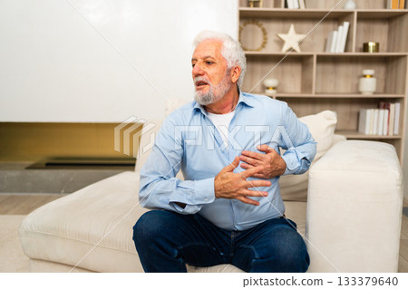 Pain on heart, heart attack. Unhappy middle aged senior man suffering from chest pain heart attack problems with health at home. Mature old senior grandfather touching chest experiencing infarction Pain on heart, heart attack. Unhappy middle aged senior man suffering from chest pain heart attack problems with health at home. Mature old senior grandfather touching chest experiencing infarction 133379640