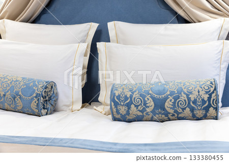 Luxurious blue and white bedroom scene featuring a canopy-inspired headboard Luxurious blue and white bedroom scene featuring a canopy-inspired headboard 133380455