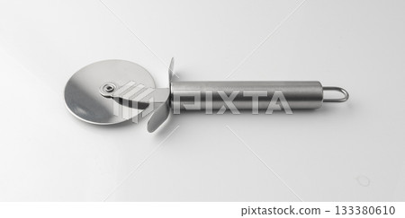 Pizza cutter isolated. Round roller knife with circle wheel, metal blade utensil Pizza cutter isolated. Round roller knife with circle wheel, metal blade utensil 133380610