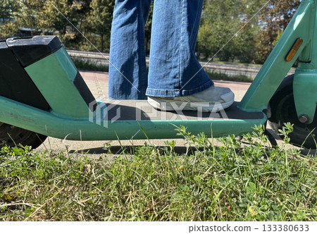 Close up feet on electric scooter 133380633