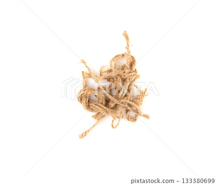 String piece isolated, jute rope fragment, part of packaging cord knots, eco-friendly natural rope 133380699