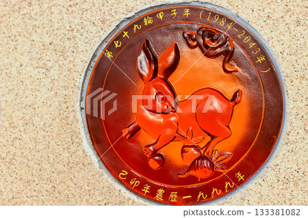 A relief sign with the Rabbit symbol and Chinese characters is placed on a wall, Nanshan Park, Sanya 133381082