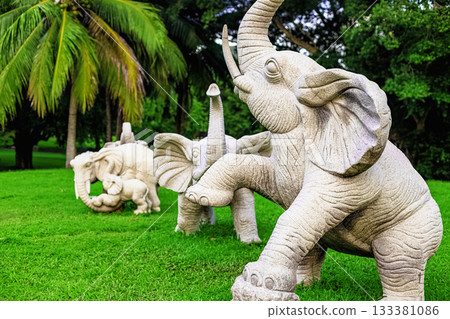 Stone sculptures of elephants in Nanshan Park, Sanya, Hainan, against a backdrop of green palm trees 133381086
