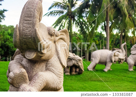 Stone sculptures of elephants in Nanshan Park, Sanya, Hainan, against a backdrop of green palm trees 133381087