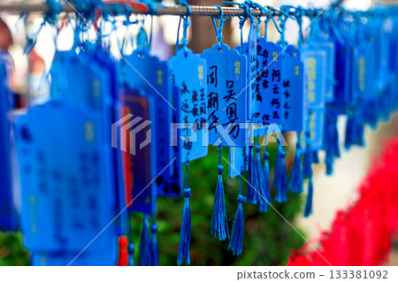 Wooden plaques with Chinese characters and images of dragons, decorated with bright blue tassels 133381092