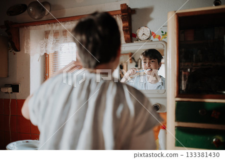 Girl brushing teeth in a modest home. 133381430