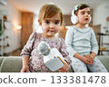 Little girl playing with karaoke microphone at home with her sister 133381478