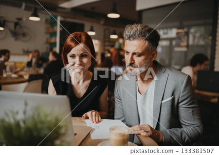 Man and woman having business meeting in a coffee shop. Man and woman having business meeting in a coffee shop. 133381507