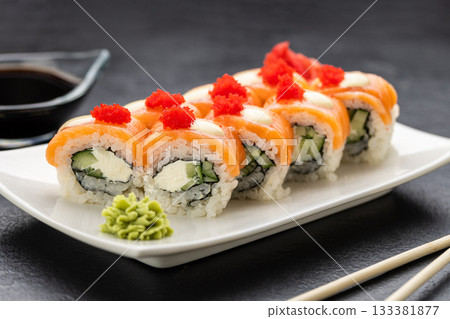 Salmon sushi rolls with cream cheese, red roe, soy sauce, wasabi and ginger, top view 133381877