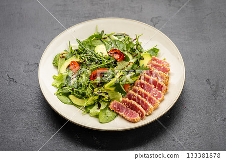 Seared tuna salad with avocado, arugula and sesame on plate, healthy gourmet lunch Seared tuna salad with avocado, arugula and sesame on plate, healthy gourmet lunch 133381878
