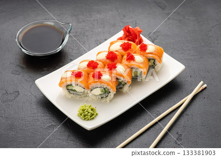 Salmon sushi rolls with cream cheese, red roe, soy sauce, wasabi and ginger, top view 133381903