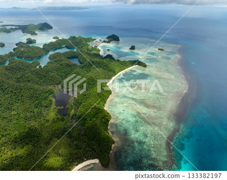 Coastal forest islands with shallow reef and village visible in distance. Siargao, Philippines. Sugba Blue Lagoon. 133382197