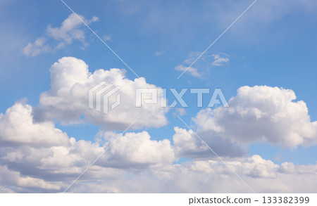Blue sky with white fluffy cumulus clouds on sunny day 133382399