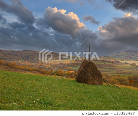 Traditional haystack standing on autumn rural hillside landscape Traditional haystack standing on autumn rural hillside landscape 133382487