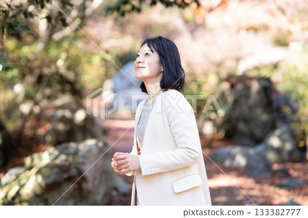 一位中年婦女在秋日的公園漫步 133382777