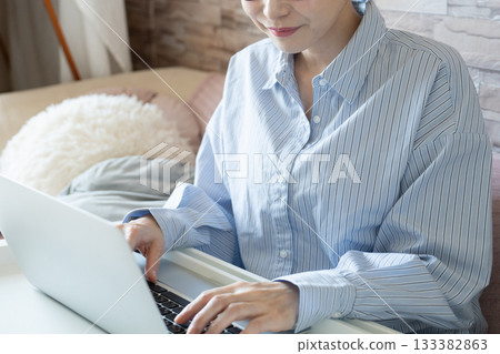 Woman using a computer in the room [parts cut] 133382863