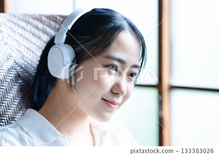 A young woman listening to music with headphones 133383026