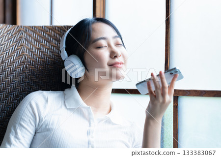 Young woman listening to smartphone music with headphones Young woman listening to smartphone music with headphones 133383067