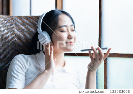 Young woman listening to smartphone music with headphones Young woman listening to smartphone music with headphones 133383068