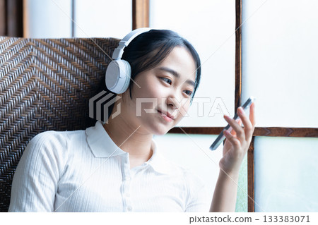 Young woman listening to smartphone music with headphones Young woman listening to smartphone music with headphones 133383071