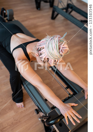 Pilates, reformer and women in class with machine for exercise, workout and improve posture. Fitness club, trainer and people with resistance equipment for wellness, health and balance for strength 133383546