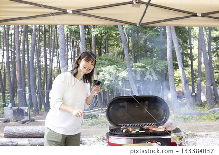 A woman enjoying a BBQ at a campsite 133384037