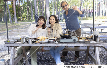 Family having a BBQ at a campsite Family having a BBQ at a campsite 133384042